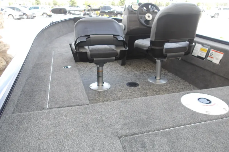 Slide: The Image of 2026 Tracker Super Guide V-16 SC boat interior with two swivel seats and carpeted flooring. - 5