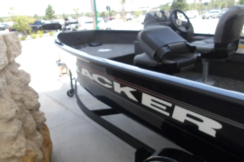 Slide: The Image of 2026 Tracker Super Guide V-16 SC boat, black exterior, parked outdoors. - 3