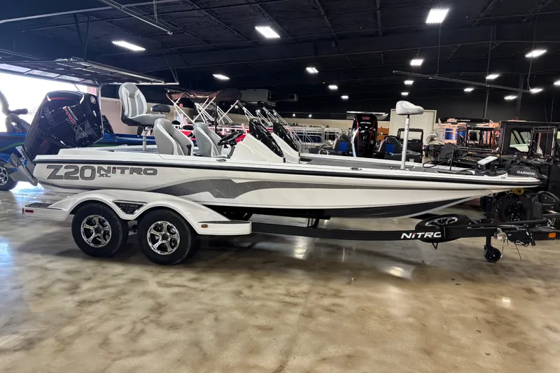 The Image of 2026 Nitro Z20 XL Pro boat in showroom, featuring sleek design and dual-axle trailer. - 1