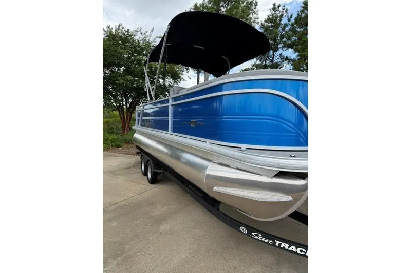 The Image of 2026 Sun Tracker Party Barge 22 RF DLX pontoon boat with blue exterior and canopy. - 0