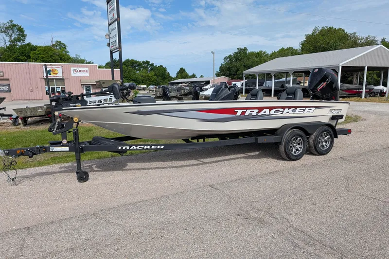 The Image of 2026 Tracker Savage 215 boat on trailer, parked outdoors near dealership. - 0