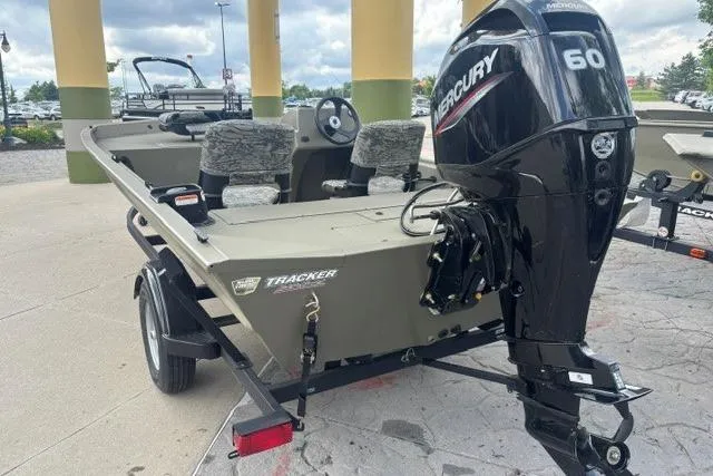 Slide: The Image of 2026 Tracker Grizzly 1754 SC boat with Mercury 60 engine, parked outdoors. - 3