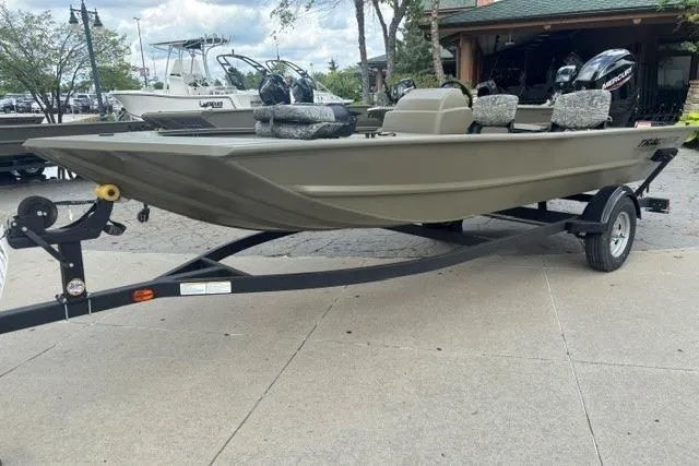 Slide: The Image of 2026 Tracker Grizzly 1754 SC boat on trailer, parked outdoors, showcasing sleek design. - 2