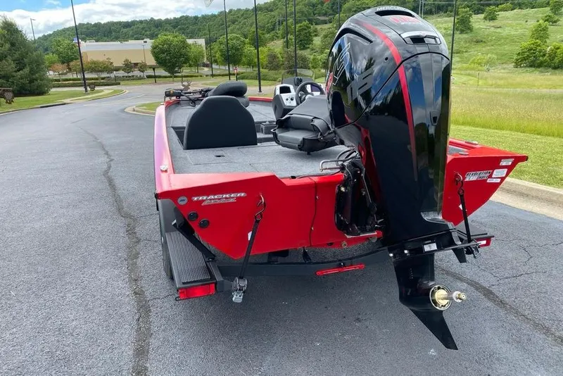 Slide: The Image of 2026 Tracker Pro Team 190 boat with powerful outboard motor, parked on a scenic road. - 4