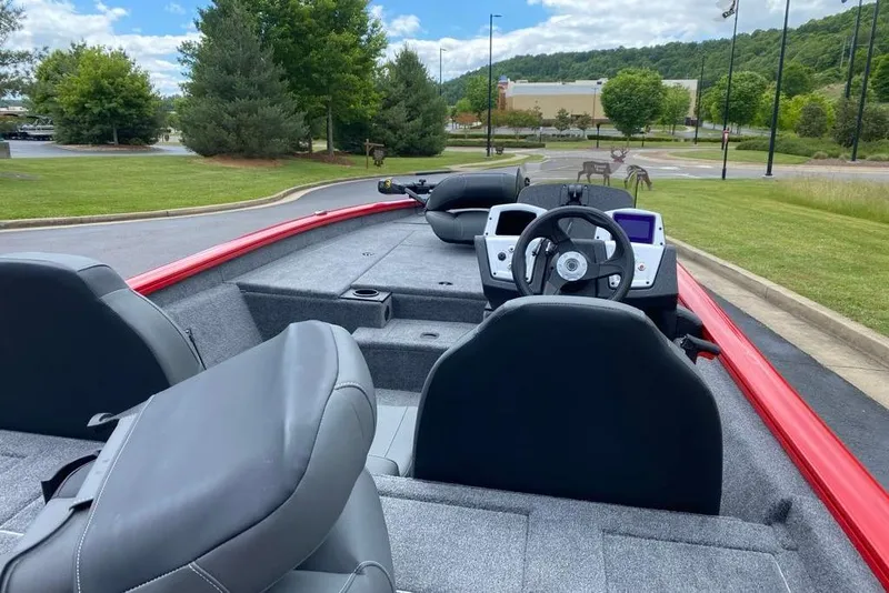Slide: The Image of 2026 Tracker Pro Team 190 boat interior with steering wheel and seating, parked outdoors. - 5