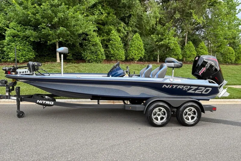 Slide: The Image of 2026 Nitro Z20 XL boat on trailer, parked on road with lush greenery background. - 1