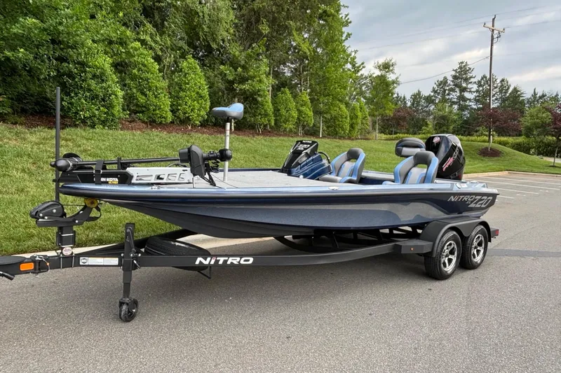Slide: The Image of 2026 Nitro Z20 XL boat on trailer, parked on road with lush greenery background. - 2