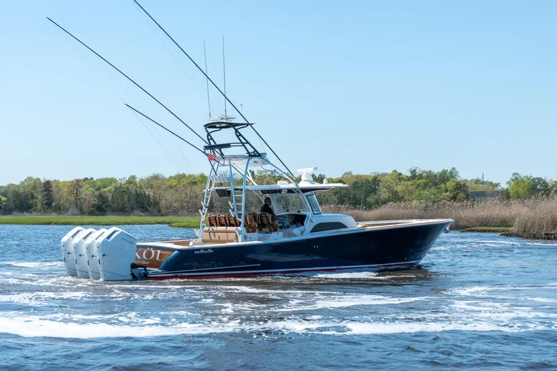 The Image of 2023 Valhalla Boatworks V-46 cruising on a scenic waterway with lush greenery. - 0