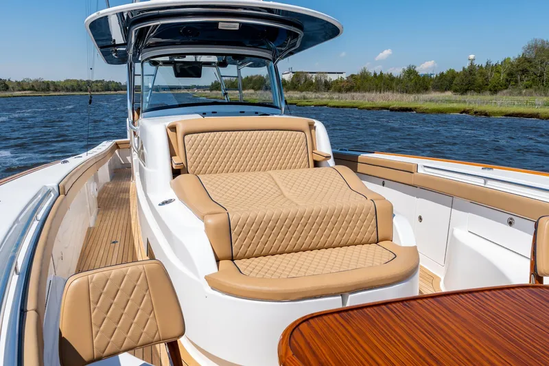 Slide: The Image of 2023 Valhalla Boatworks V-46 luxury interior with tan seating on a sunny day. - 10