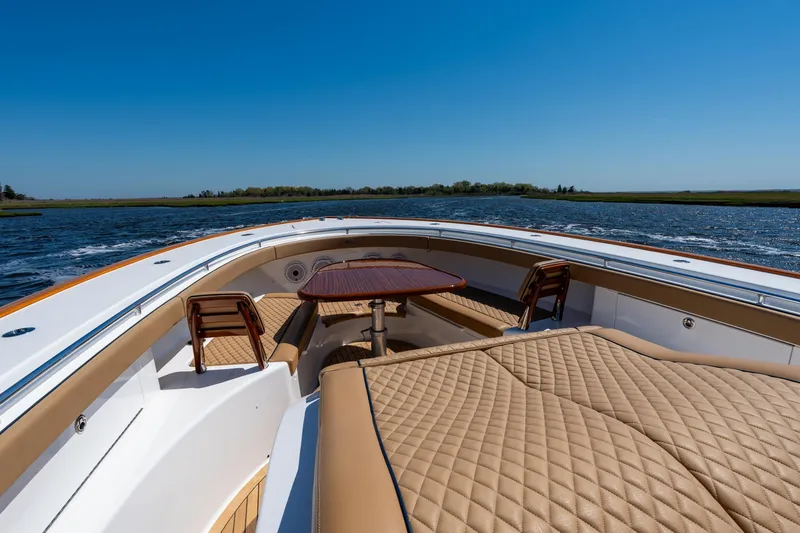 Slide: The Image of 2023 Valhalla Boatworks V-46 interior with luxurious seating and table on open water. - 11
