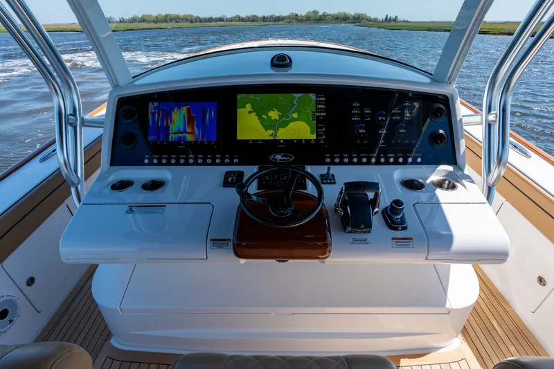 Slide: The Image of 2023 Valhalla Boatworks V-46 helm with advanced navigation displays on open water. - 16