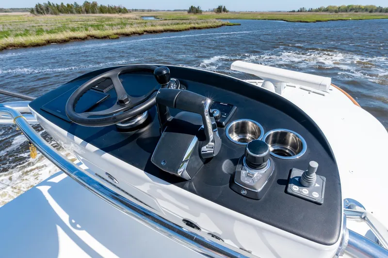 Slide: The Image of 2023 Valhalla Boatworks V-46 helm with steering wheel and controls on open water. - 24