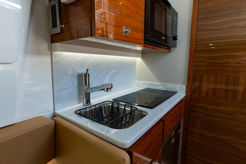 Slide: The Image of Modern kitchen area in 2023 Valhalla Boatworks V-46, featuring sink, stovetop, and microwave. - 29