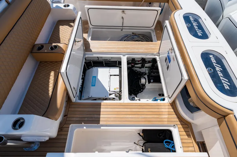 Slide: The Image of 2023 Valhalla Boatworks V-46 deck with open storage compartments and tan seating. - 34