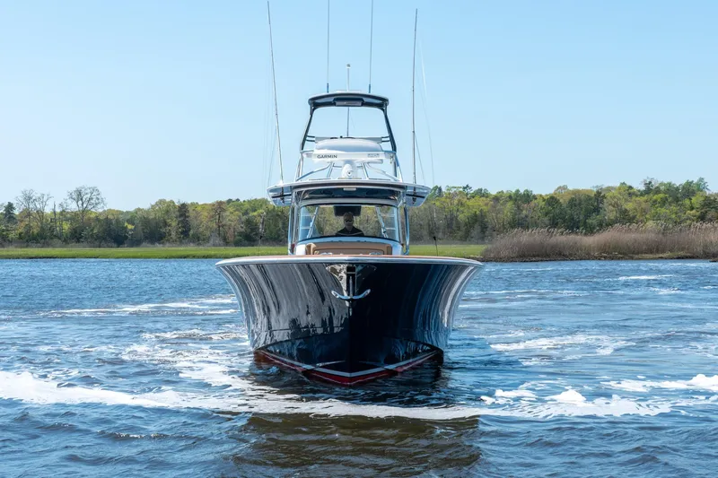 Slide: The Image of 2023 Valhalla Boatworks V-46 cruising on a serene lake with lush greenery. - 5