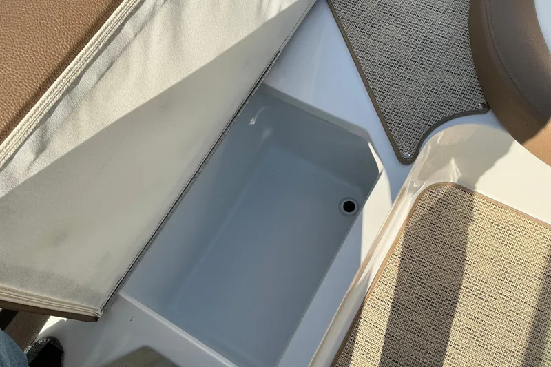 Slide: The Image of 2019 Cobalt CS23 boat storage compartment with beige upholstery and textured flooring. - 10