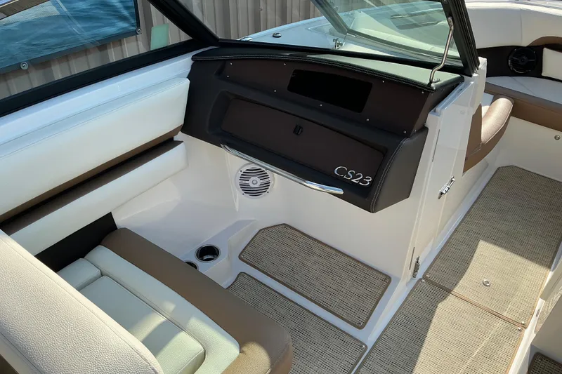 Slide: The Image of 2019 Cobalt CS23 boat interior with beige seating and carpeted flooring. - 13