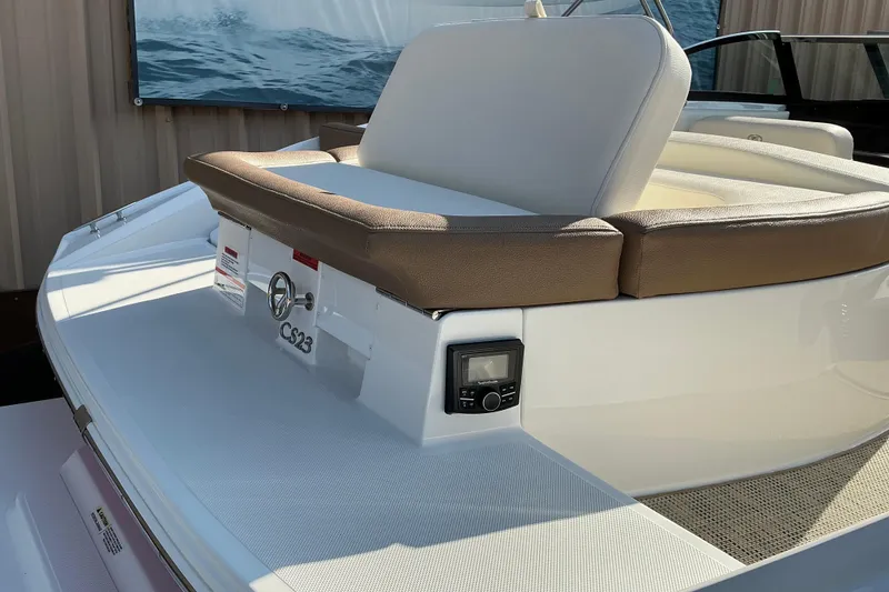 Slide: The Image of 2019 Cobalt CS23 boat with cushioned seating and control panel, docked outdoors. - 17