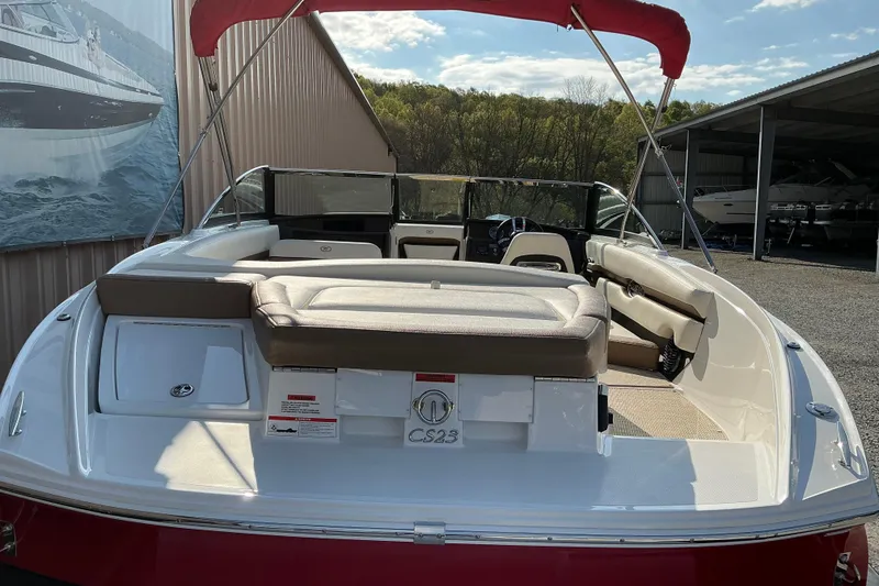Slide: The Image of 2019 Cobalt CS23 boat with red canopy, docked near a storage facility. - 4