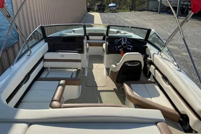 Slide: The Image of 2019 Cobalt CS23 boat interior with seating and steering wheel, docked near water. - 5