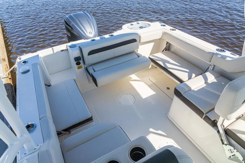 Slide: The Image of 2027 Sailfish 245 DC boat interior with seating, docked by water. - 12