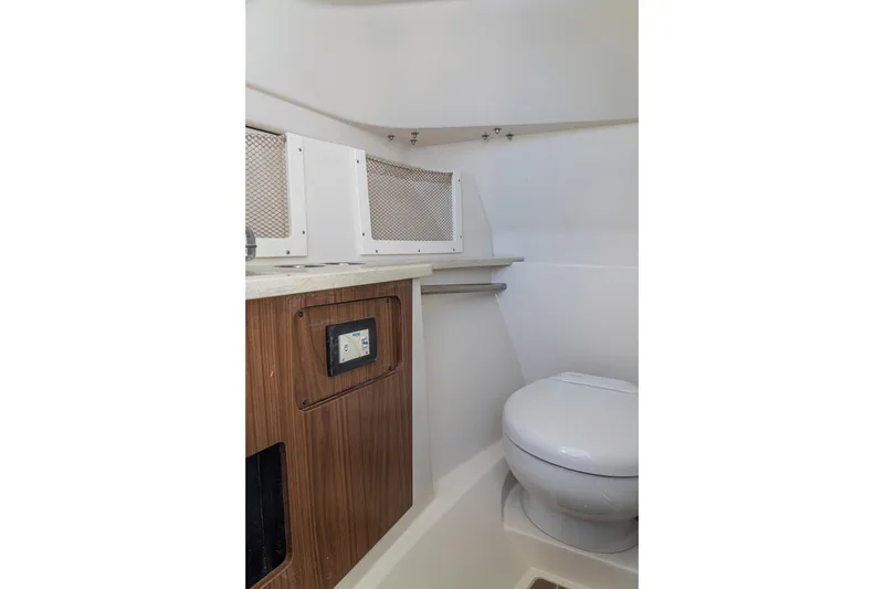 Slide: The Image of Interior of 2027 Sailfish 245 DC boat featuring a compact bathroom with toilet. - 17