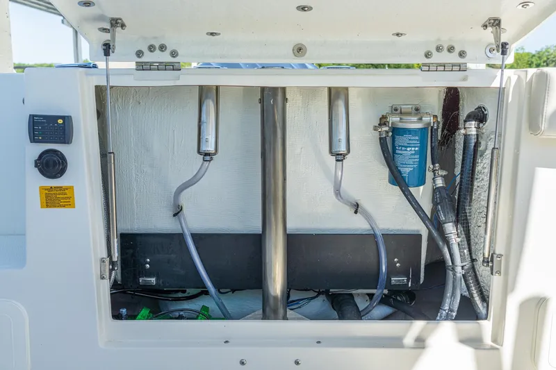Slide: The Image of 2027 Sailfish 245 DC boat compartment with hoses, filters, and control panel. - 18