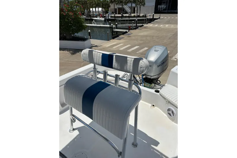 Slide: The Image of 2008 Pro-Line 20 Sport boat with blue and white seating, docked near a marina. - 6