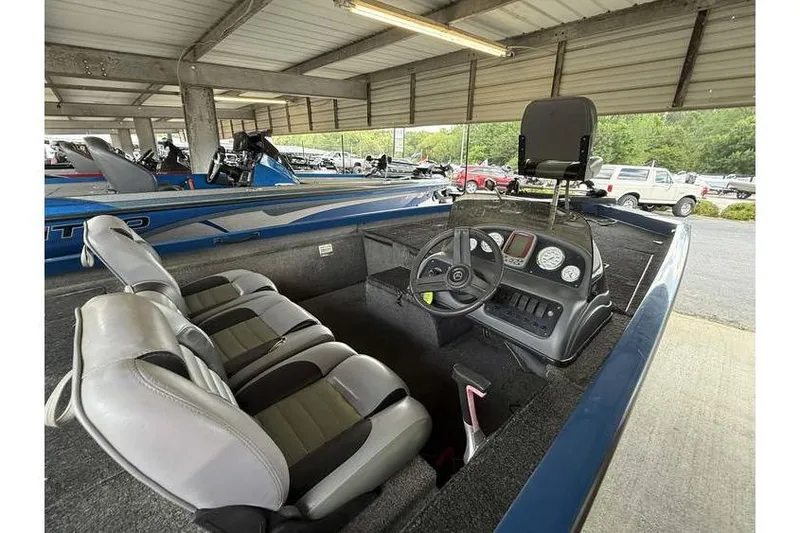 Slide: The Image of 2008 Triton TS-18 boat interior with steering wheel and seating under a covered area. - 2