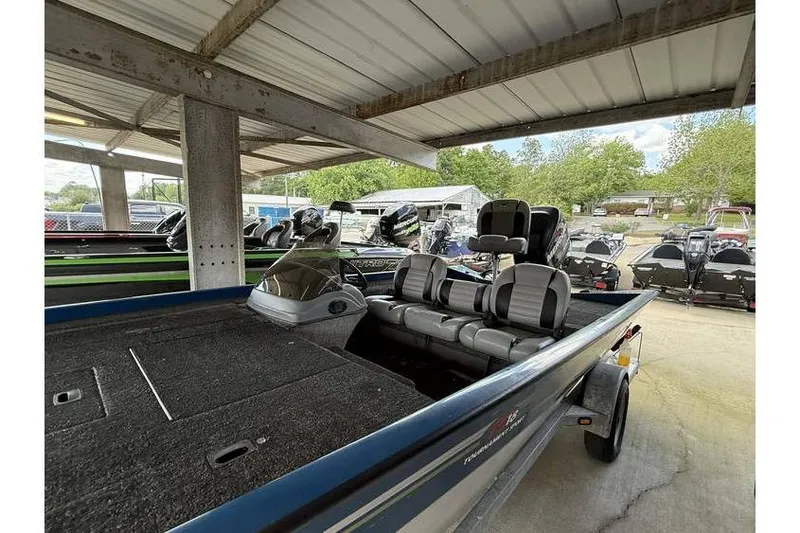 Slide: The Image of 2008 Triton TS-18 boat with seating, parked under a shelter. - 6