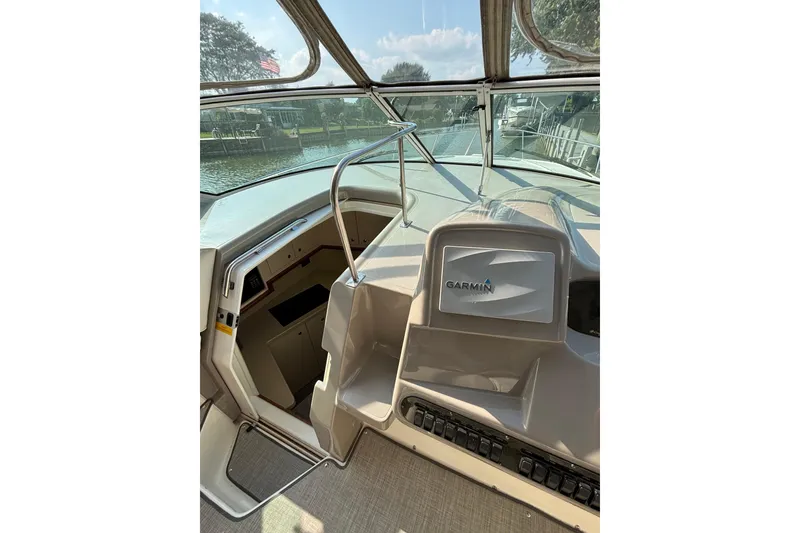 Slide: The Image of 2003 Cruisers Yachts 3470 Express cockpit with Garmin navigation system and open cabin entrance. - 10
