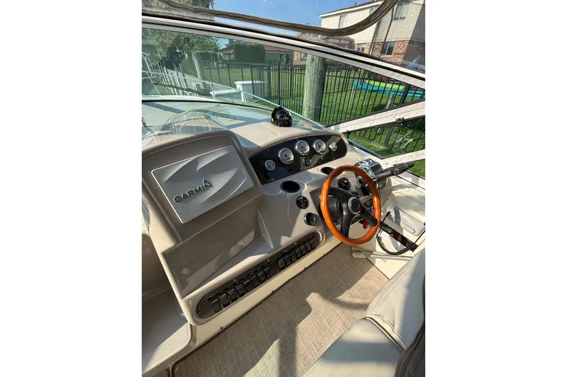 Slide: The Image of 2003 Cruisers Yachts 3470 Express helm with Garmin navigation and wood-accented steering wheel. - 11