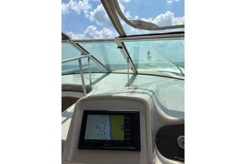 Slide: The Image of 2003 Cruisers Yachts 3470 Express dashboard with navigation screen, under a clear blue sky. - 12