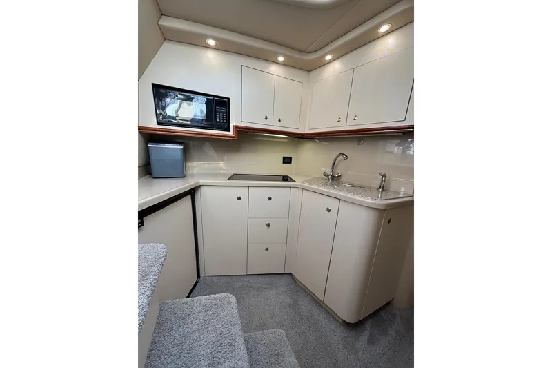 Slide: The Image of 2003 Cruisers Yachts 3470 Express interior kitchen with modern amenities and sleek cabinetry. - 18