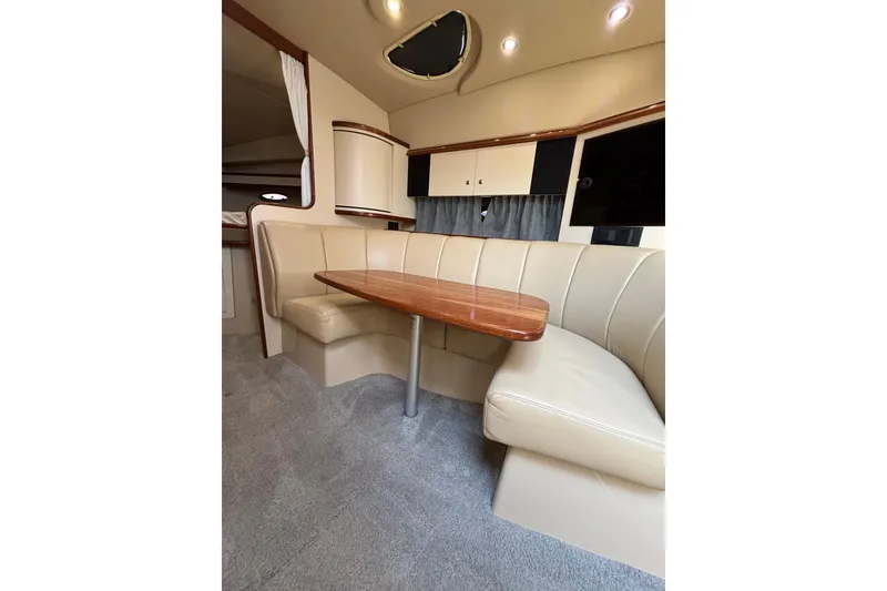 Slide: The Image of Interior of 2003 Cruisers Yachts 3470 Express with beige seating and wooden table. - 20