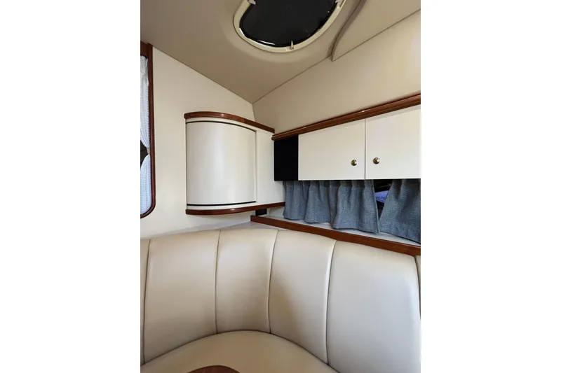 Slide: The Image of 2003 Cruisers Yachts 3470 Express interior with beige seating and wooden cabinetry. - 22