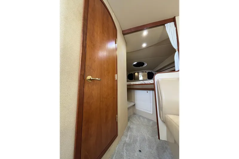 Slide: The Image of Interior of 2003 Cruisers Yachts 3470 Express, featuring wood door and cozy cabin space. - 23