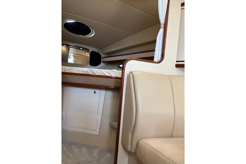 Slide: The Image of Interior of 2003 Cruisers Yachts 3470 Express, featuring beige seating and wood accents. - 24