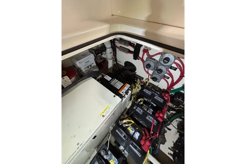 Slide: The Image of Engine compartment of 2003 Cruisers Yachts 3470 Express, showcasing batteries and wiring. - 30