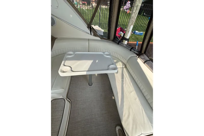 Slide: The Image of 2003 Cruisers Yachts 3470 Express interior with white seating and a small table. - 8