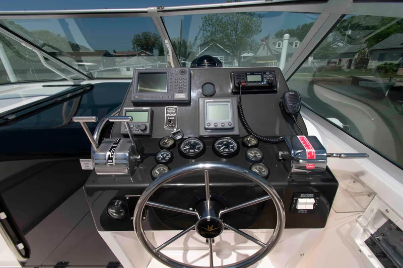 Slide: The Image of Cockpit of a 1995 Bertram 30 Moppie boat with steering wheel and navigation instruments. - 11