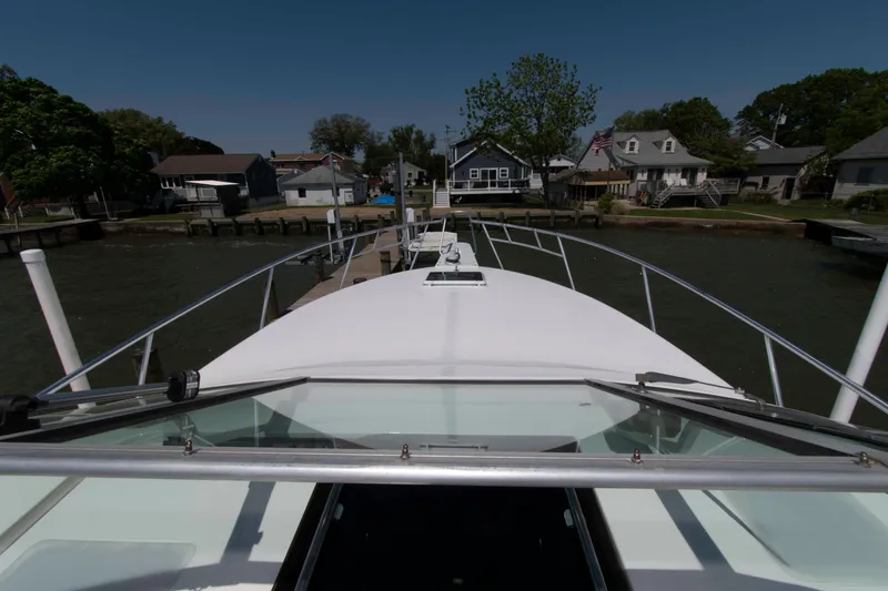 Slide: The Image of 1995 Bertram 30 Moppie boat docked at a scenic waterfront neighborhood. - 12