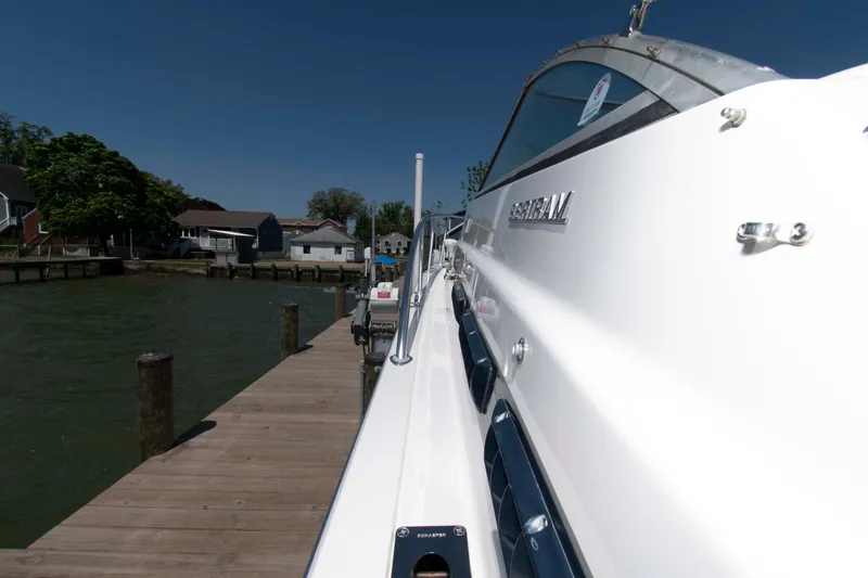 Slide: The Image of 1995 Bertram 30 Moppie docked by a wooden pier on a sunny day. - 13