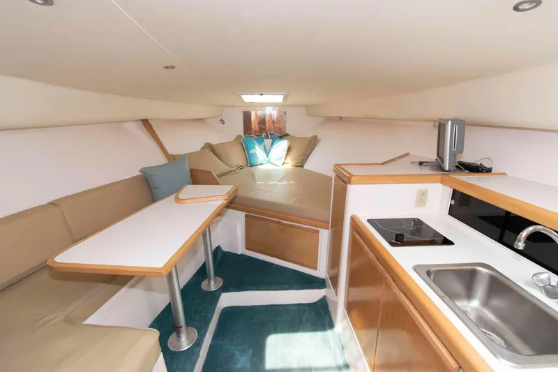 Slide: The Image of Interior of a 1995 Bertram 30 Moppie boat with kitchenette and seating area. - 14