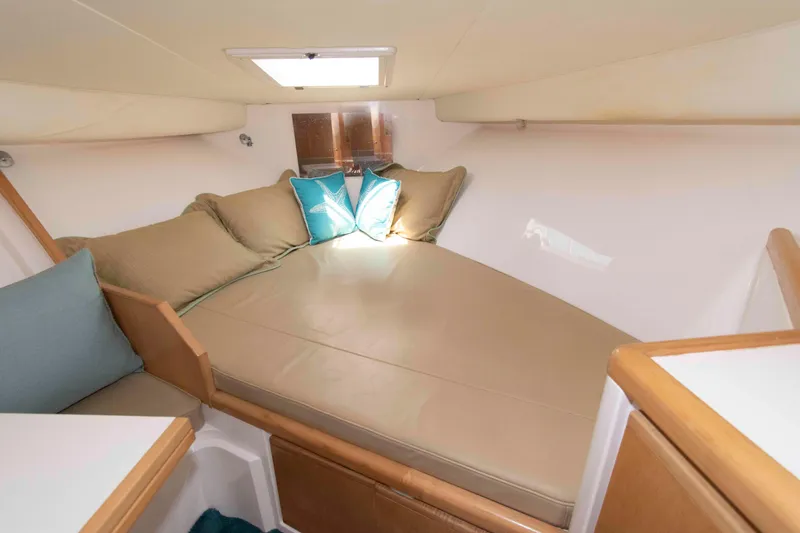 Slide: The Image of Cozy cabin interior of 1995 Bertram 30 Moppie with beige cushions and decorative pillows. - 16