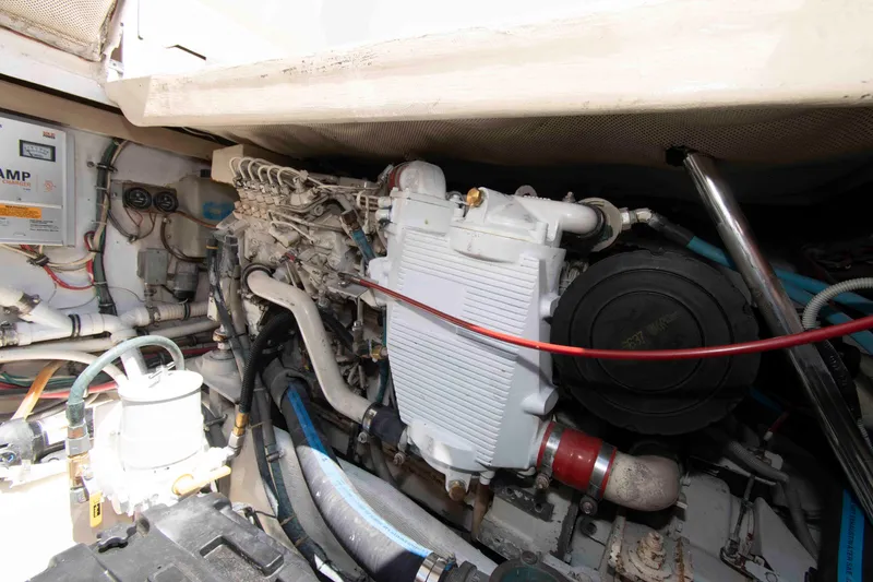 Slide: The Image of Engine compartment of a 1995 Bertram 30 Moppie boat, showcasing mechanical components and wiring. - 20