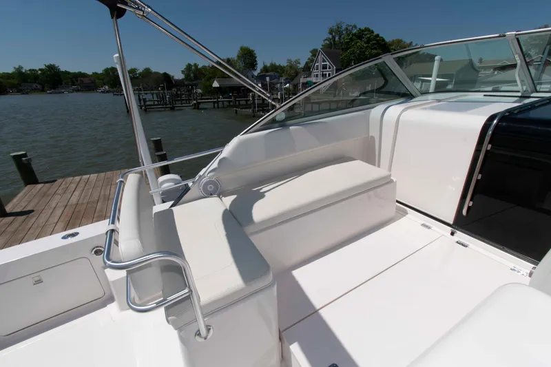 Slide: The Image of 1995 Bertram 30 Moppie boat interior with white seating and dock view. - 8