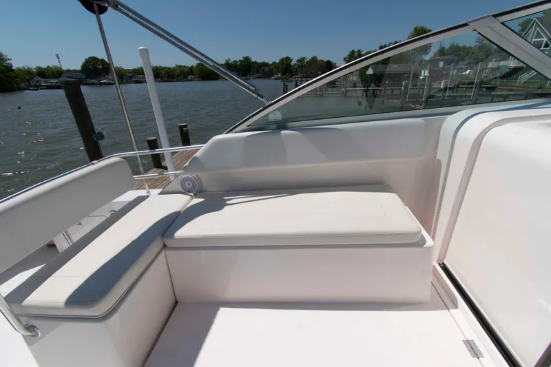Slide: The Image of 1995 Bertram 30 Moppie boat interior with white seating, docked by a calm river. - 9