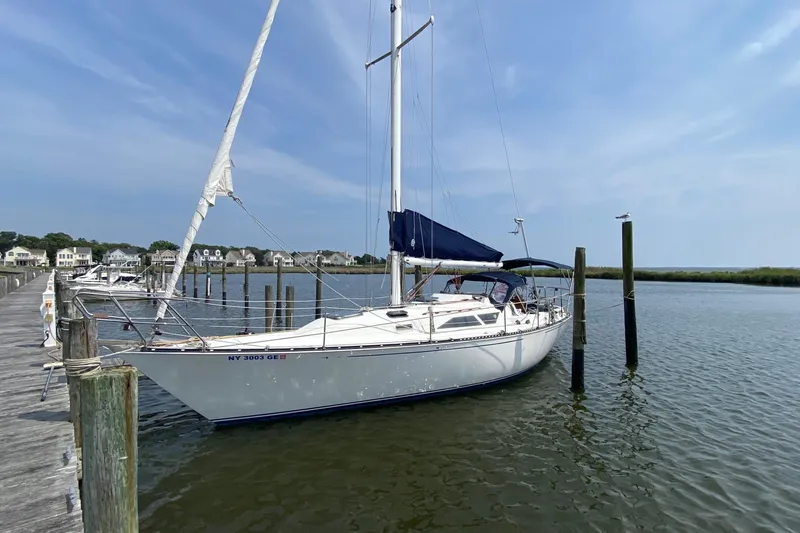 The Image of 1987 C&C Mark III sailboat docked at a marina under a clear blue sky. - 0
