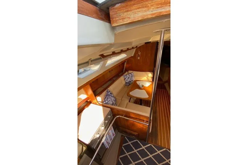 Slide: The Image of Interior of 1987 C&C Mark III sailboat with cozy seating and wooden accents. - 11